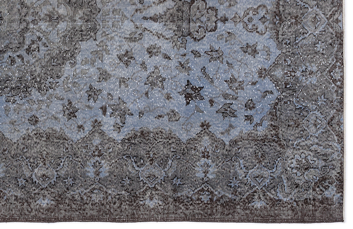 Charcoal and slate blue traditional rug with a distressed, faded floral medallion pattern.