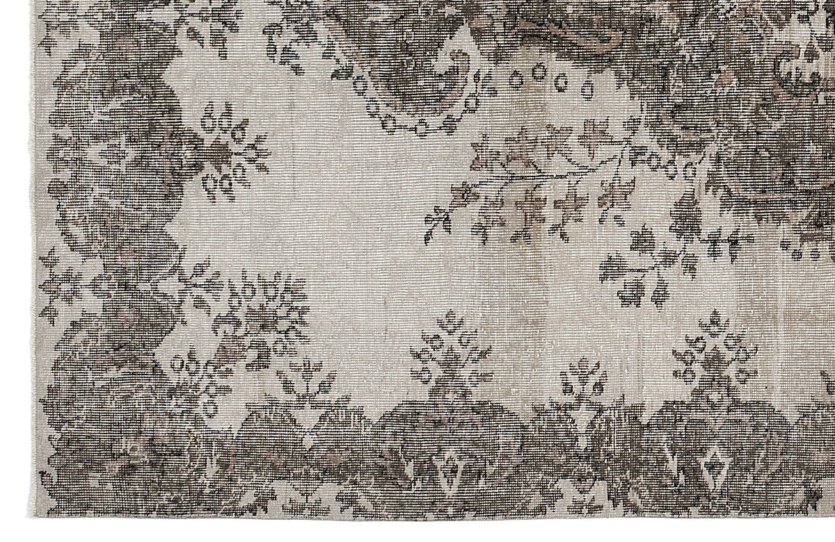 Distressed charcoal and cream rug featuring a traditional floral medallion pattern with ornate borders.