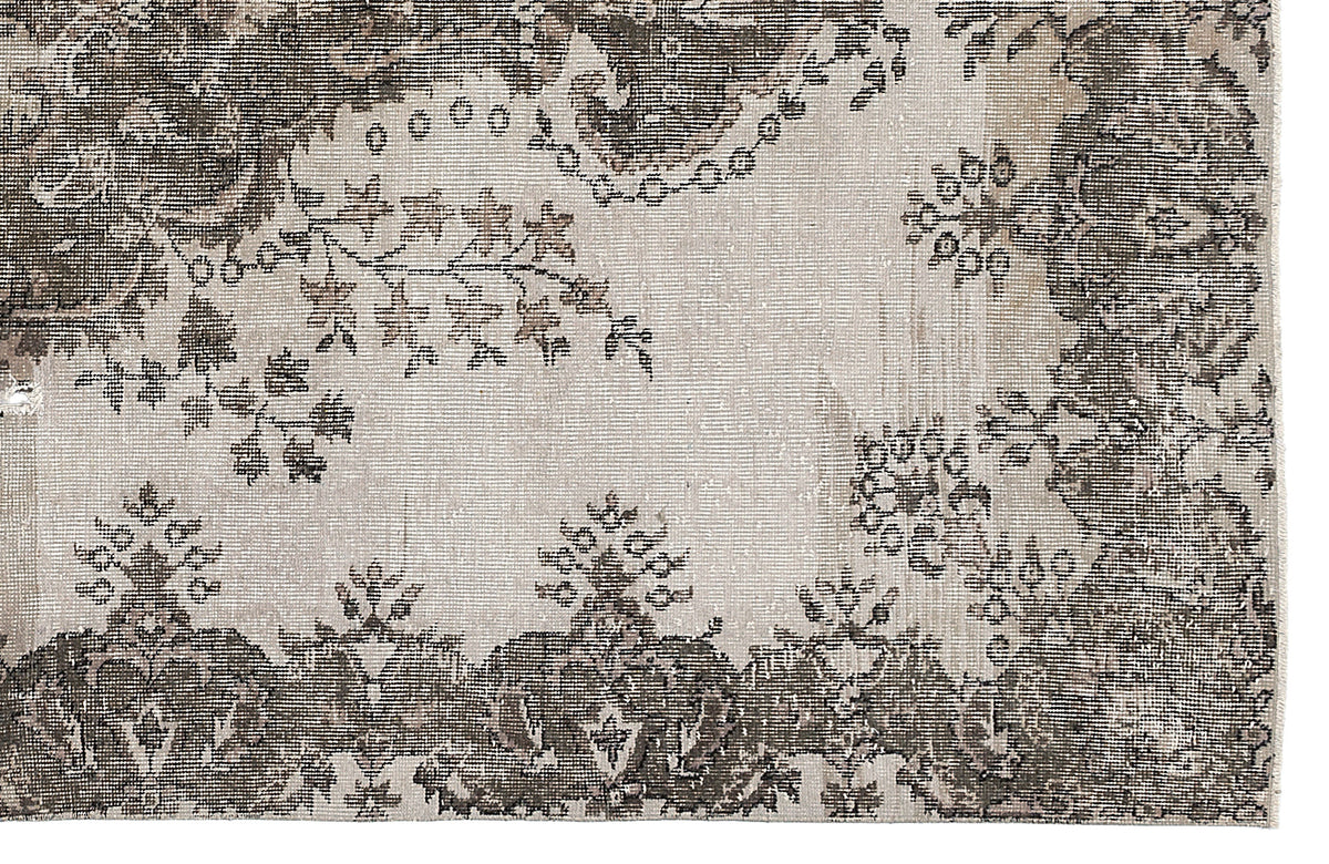 Distressed charcoal and cream rug with a traditional floral medallion and vine pattern.