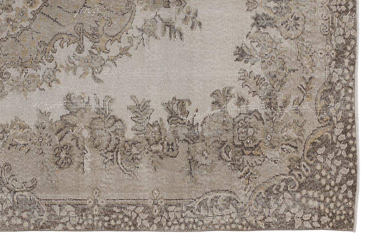Beige and taupe distressed rug with a faded floral medallion pattern and a detailed botanical border.