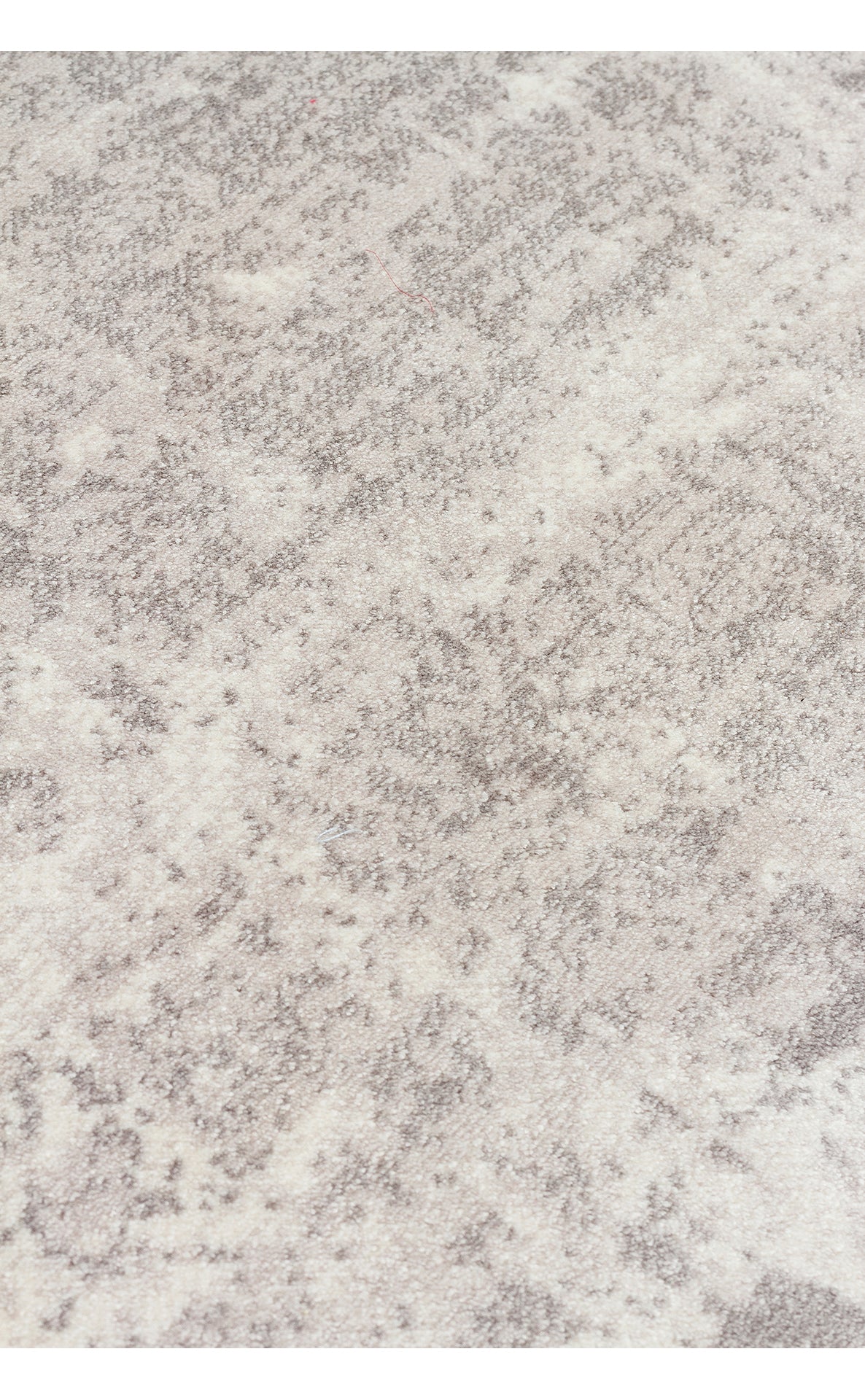 Close-up of a grey and cream rug with a soft, mottled abstract texture.