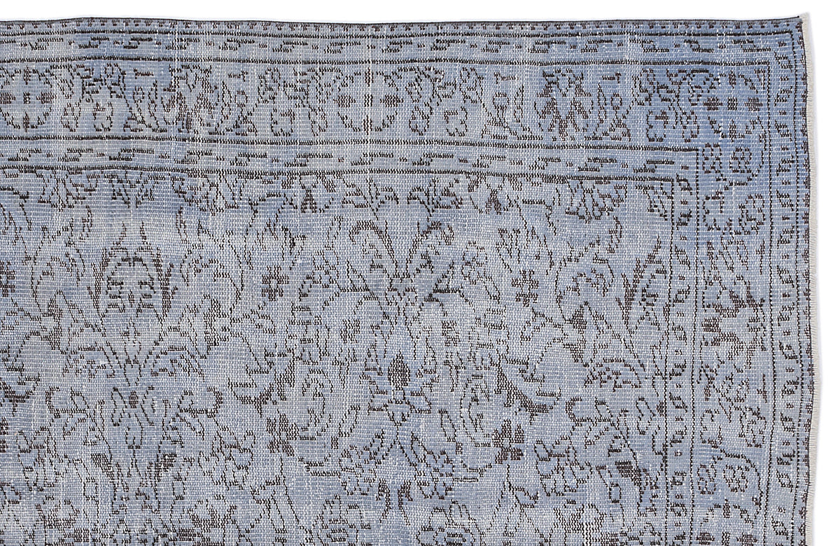 Light blue and charcoal grey rug with a distressed traditional floral medallion pattern and a detailed border.