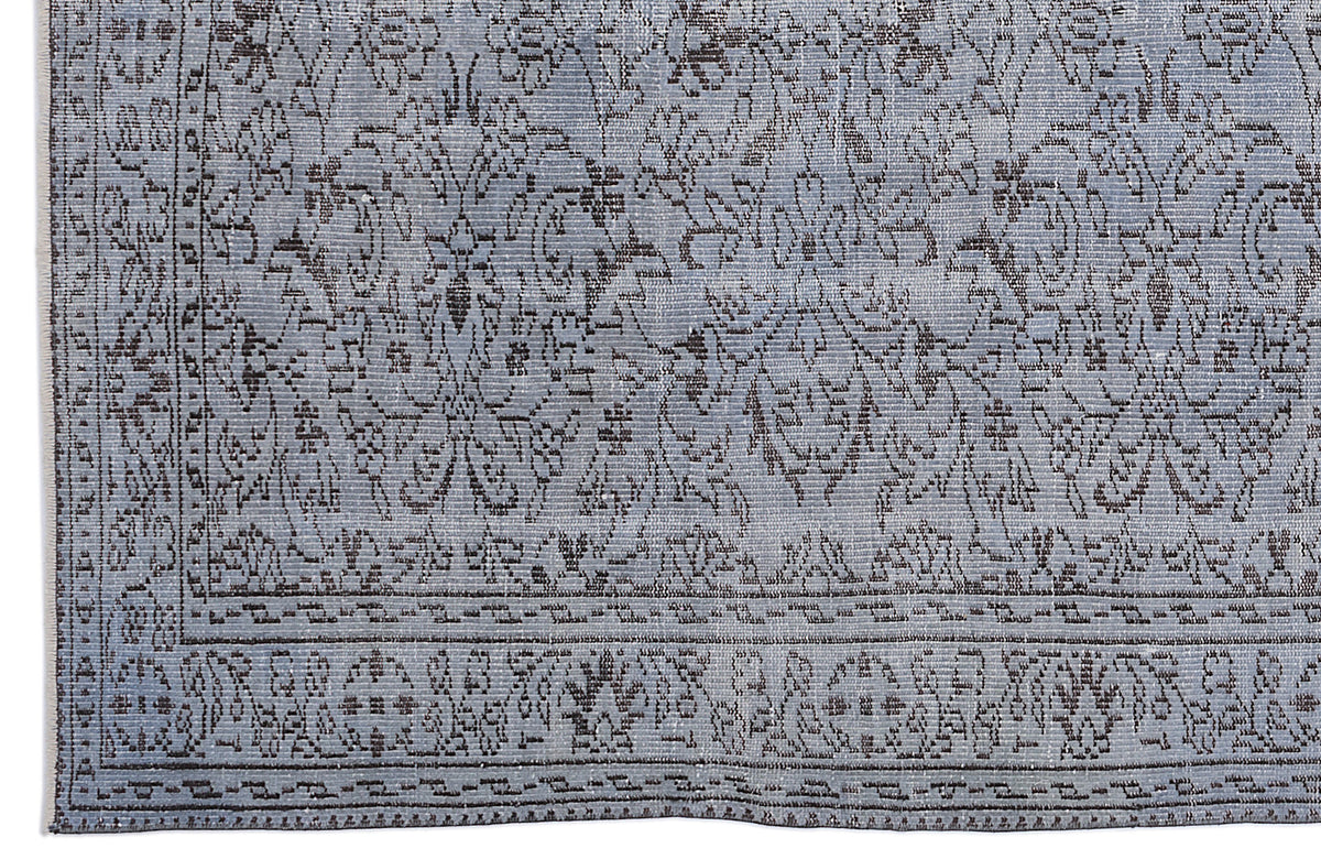 Light blue and charcoal grey rug with a distressed traditional floral medallion pattern and a geometric border.