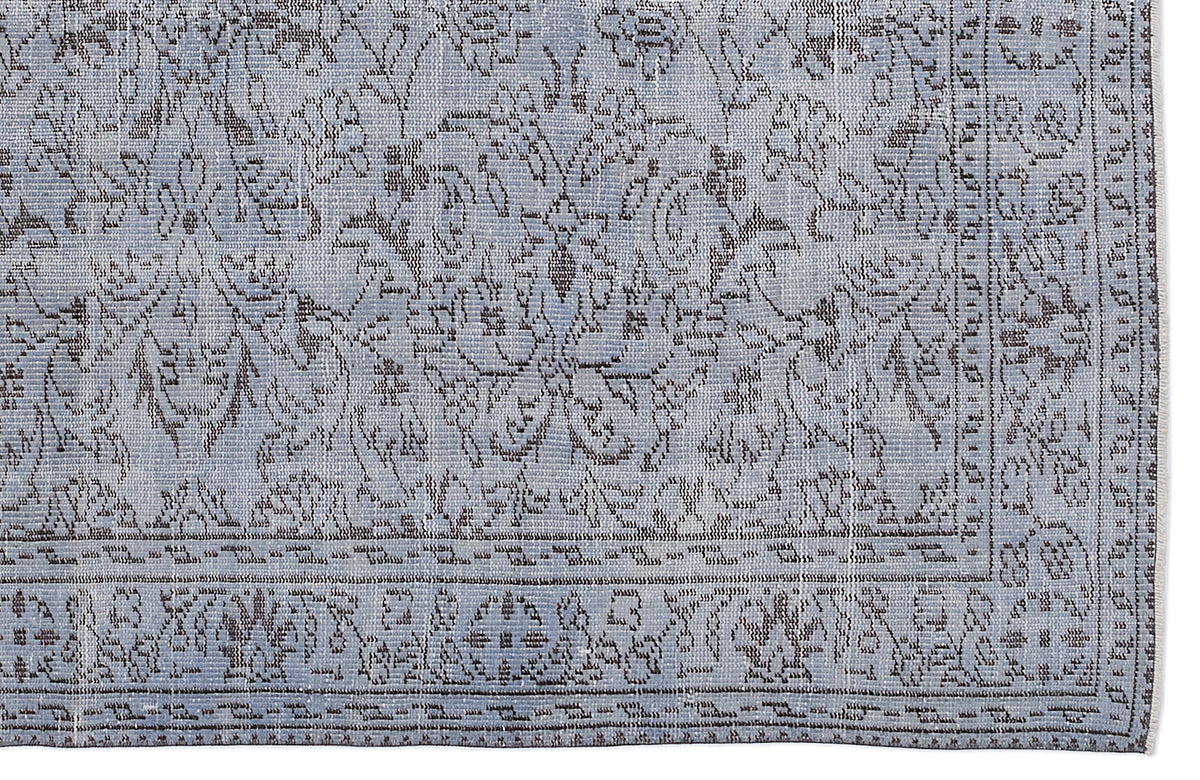 Light blue and charcoal grey rug with a traditional floral medallion pattern and a detailed geometric border.