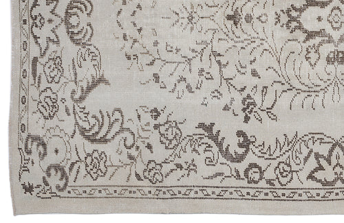 Load image 1 in gallery view. Beige rug with a distressed brown floral medallion pattern and a decorative border.