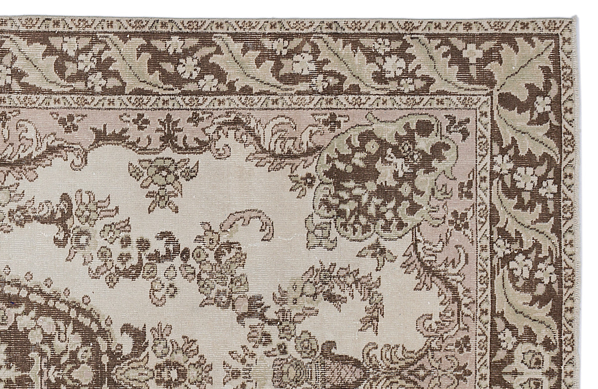 Beige, brown, and sage green traditional rug with a distressed floral medallion pattern and ornate border.