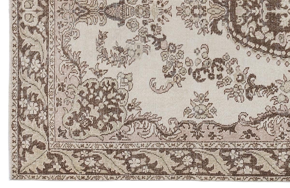 Beige and brown traditional rug with a distressed floral medallion pattern and a detailed border.