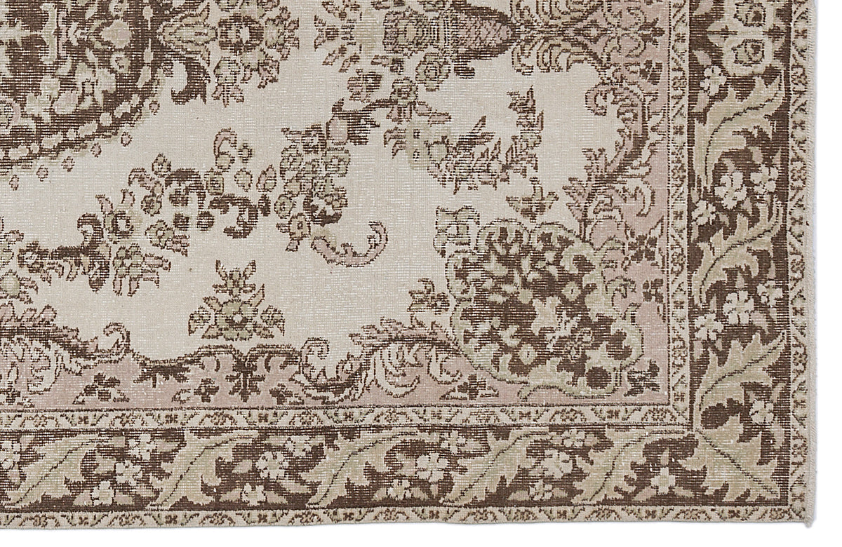 Beige and brown traditional rug with a distressed floral medallion pattern and a detailed decorative border.
