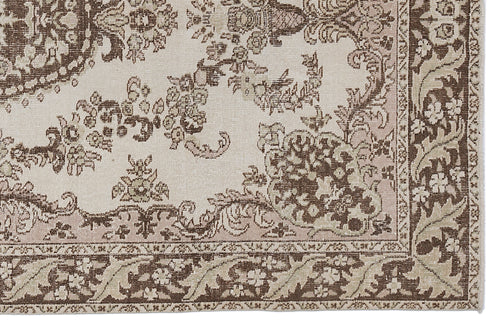 Load image 1 in gallery view. Beige and brown traditional rug with a distressed floral medallion pattern and a detailed decorative border.
