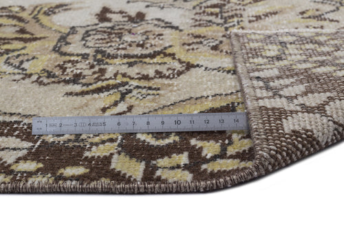 Load image 1 in gallery view. Beige, brown, and yellow vintage-style rug with a floral medallion pattern, shown with a ruler for scale.