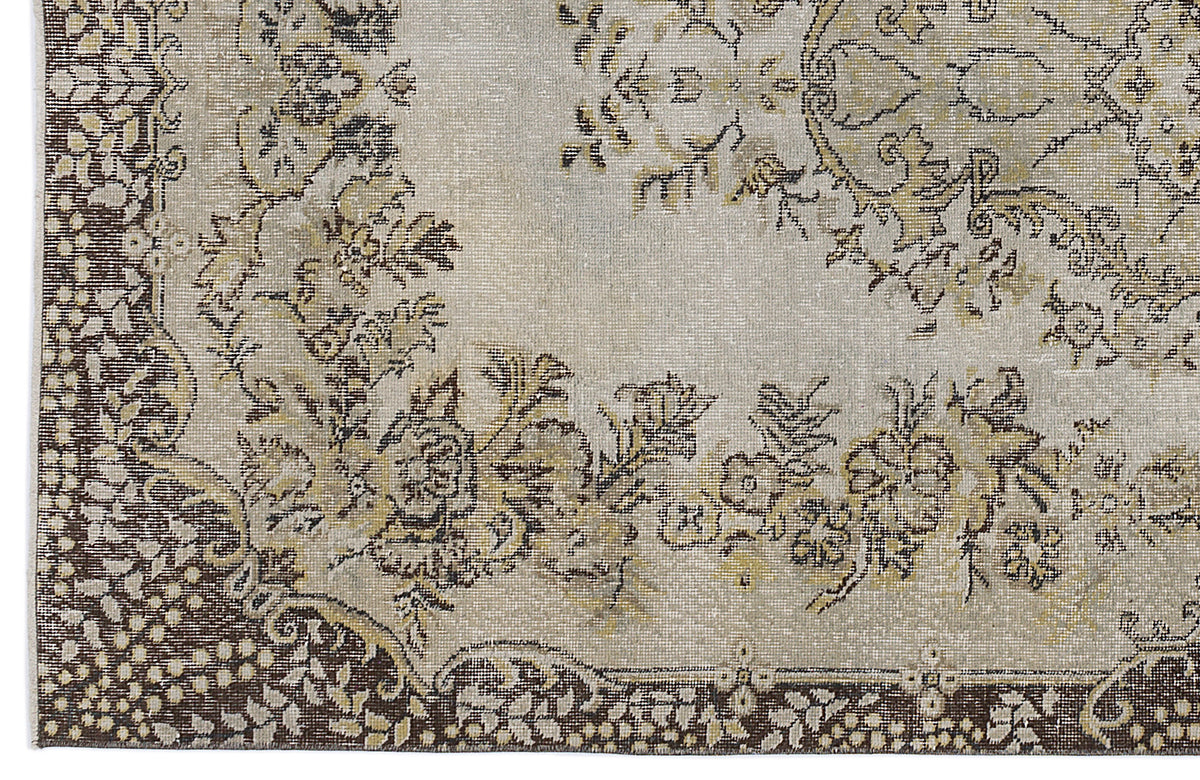 Beige and brown traditional rug with a distressed floral medallion pattern and ornate border.