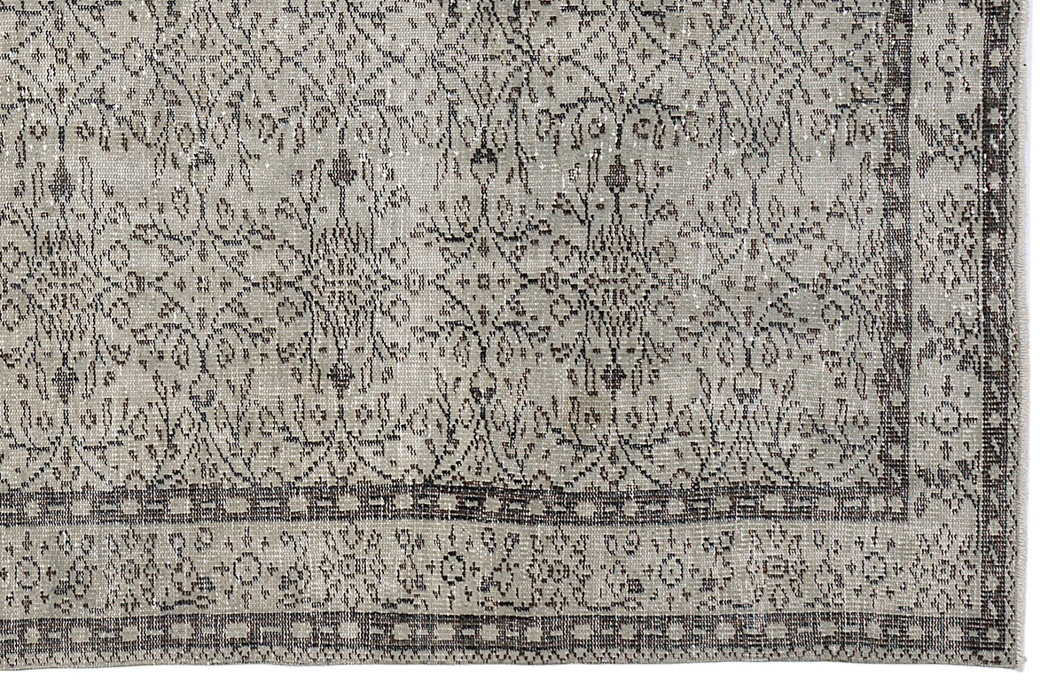 Grey and charcoal distressed rug with a traditional floral medallion pattern and a detailed geometric border.