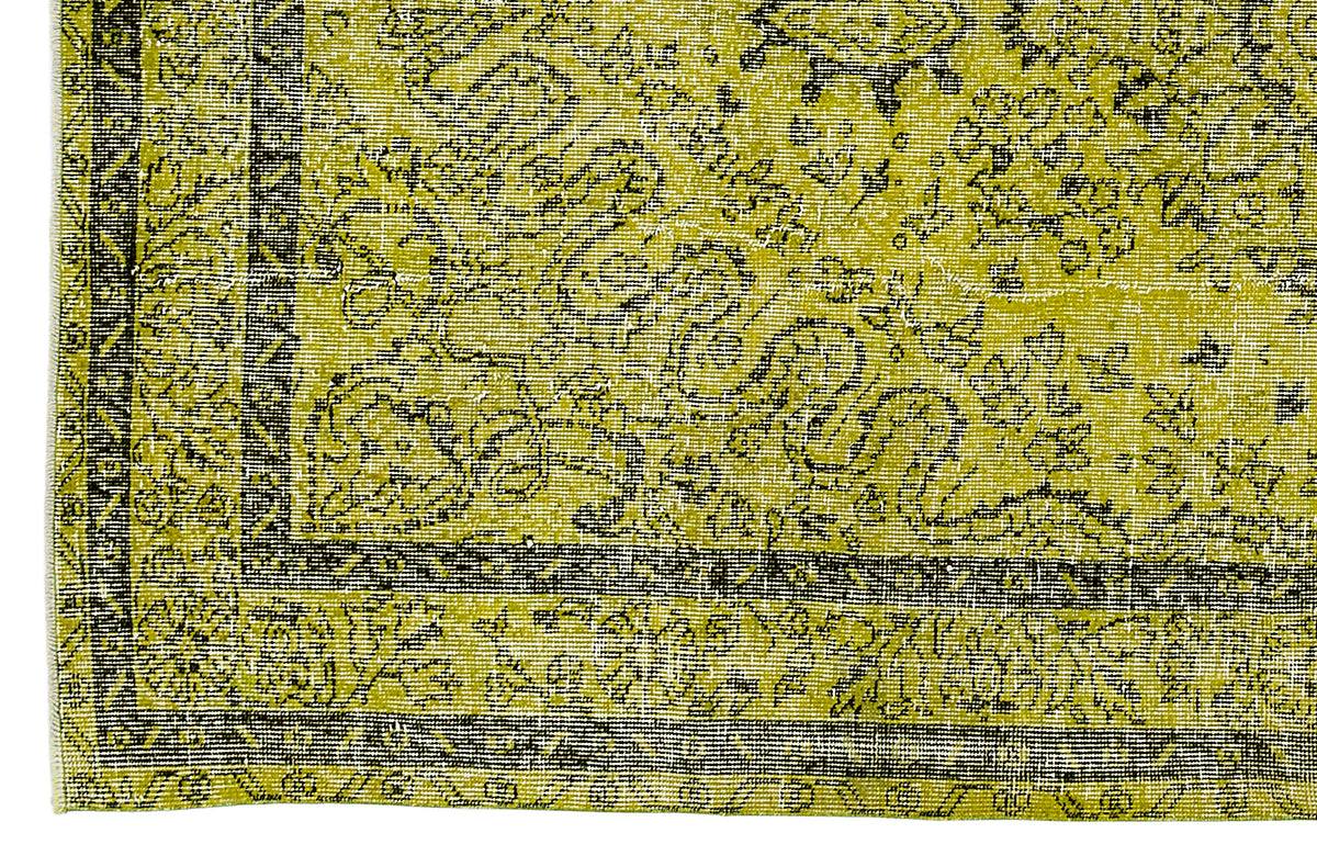 Chartreuse and black rug with a distressed traditional floral pattern and a geometric border.