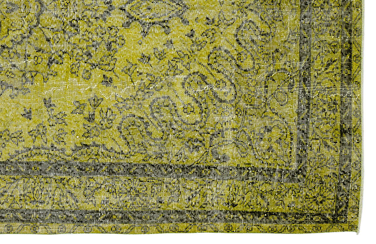 Chartreuse and black distressed rug with a traditional floral medallion pattern and a geometric border.