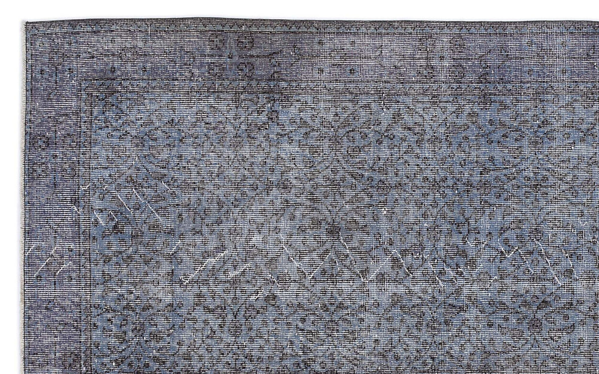 Slate blue and charcoal grey rug with a distressed, traditional floral medallion pattern and a geometric border.