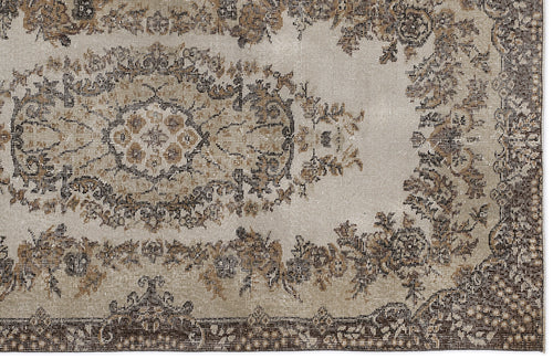 Load image 1 in gallery view. Distressed beige and brown rug with a traditional floral medallion pattern and a dark decorative border.