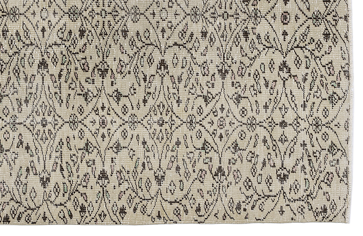 Beige rug with a dark brown diamond lattice pattern featuring small floral and geometric motifs.