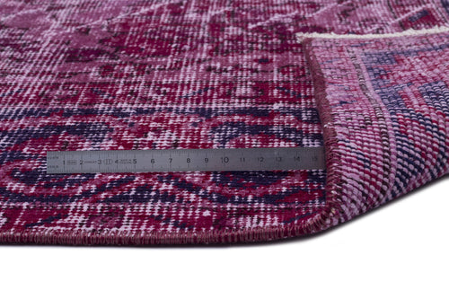 Load image 1 in gallery view. Magenta and dark purple distressed-style rug with a folded corner and a metal ruler for scale.