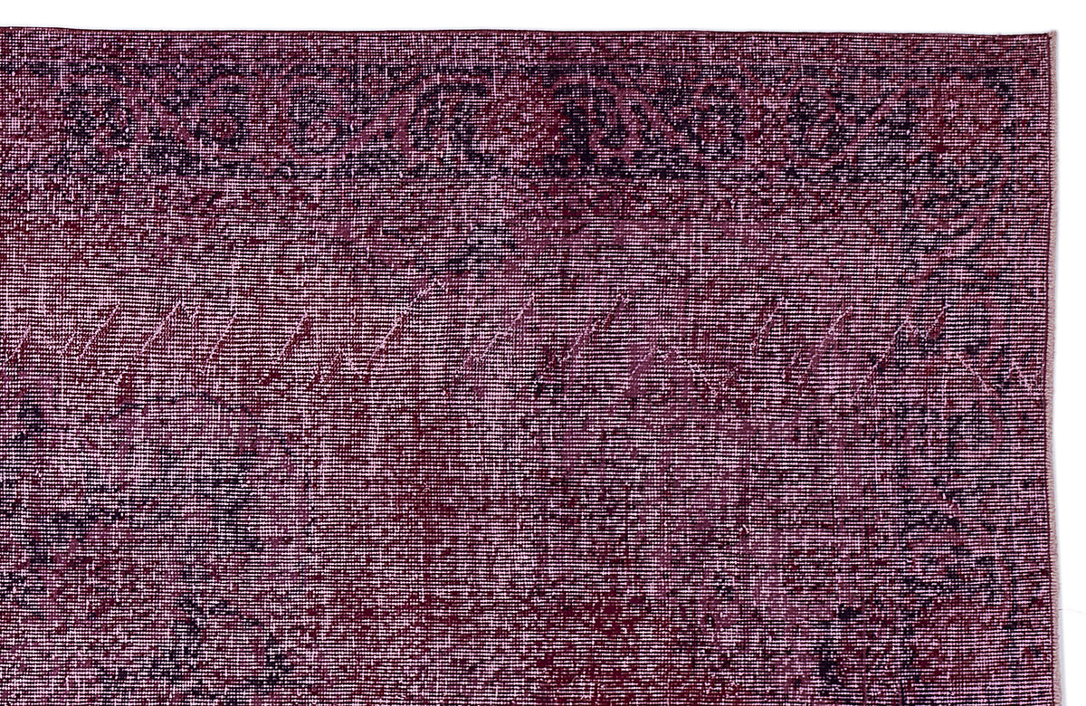 Deep magenta and black distressed rug with a traditional ornate border and faded central medallion pattern.