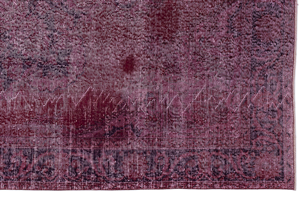 Deep burgundy and black distressed rug with a faded traditional border pattern.