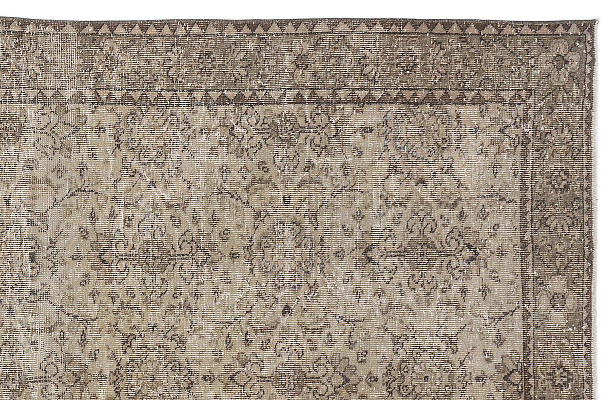 Taupe and brown distressed vintage-style rug with a traditional floral medallion pattern and geometric border.