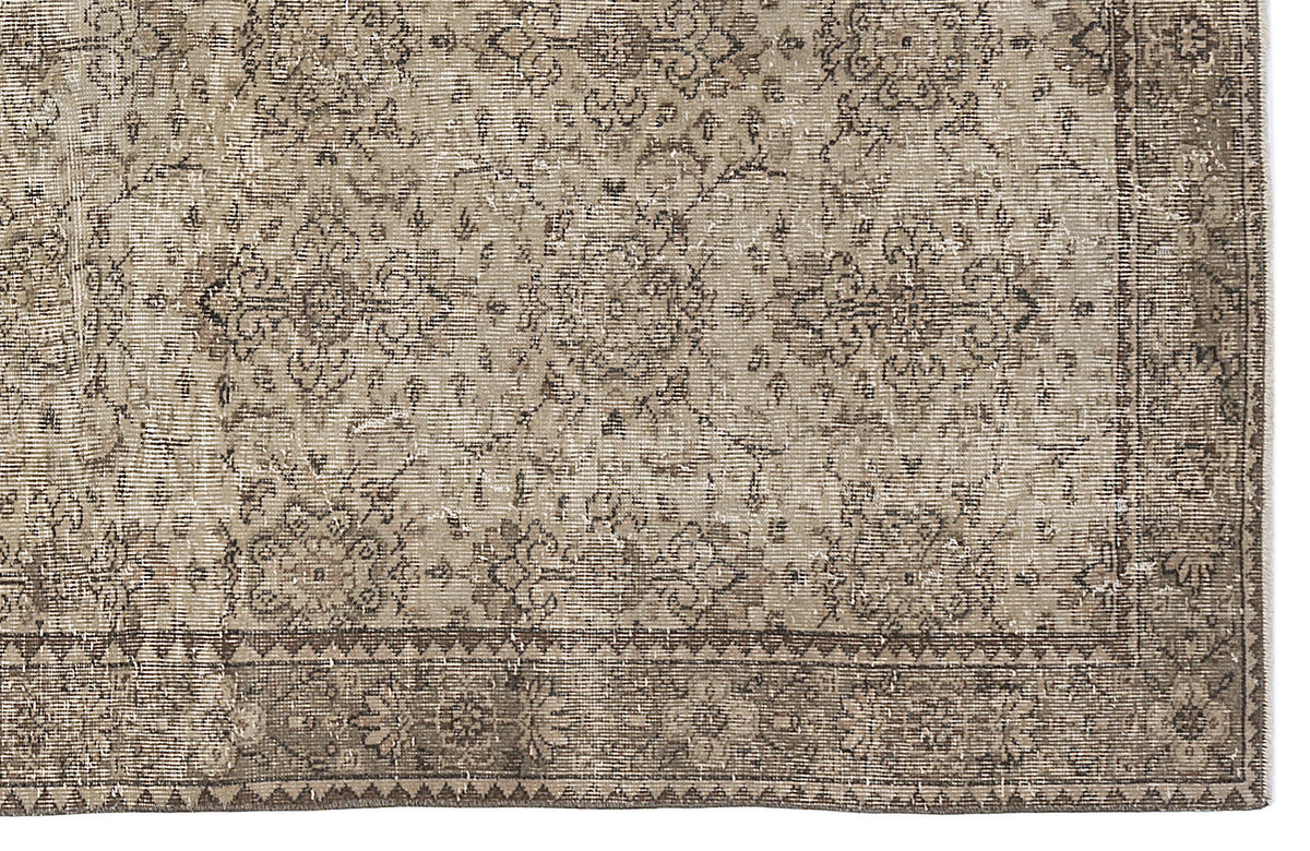 Taupe and beige vintage-style rug with a distressed floral medallion pattern and a geometric border.