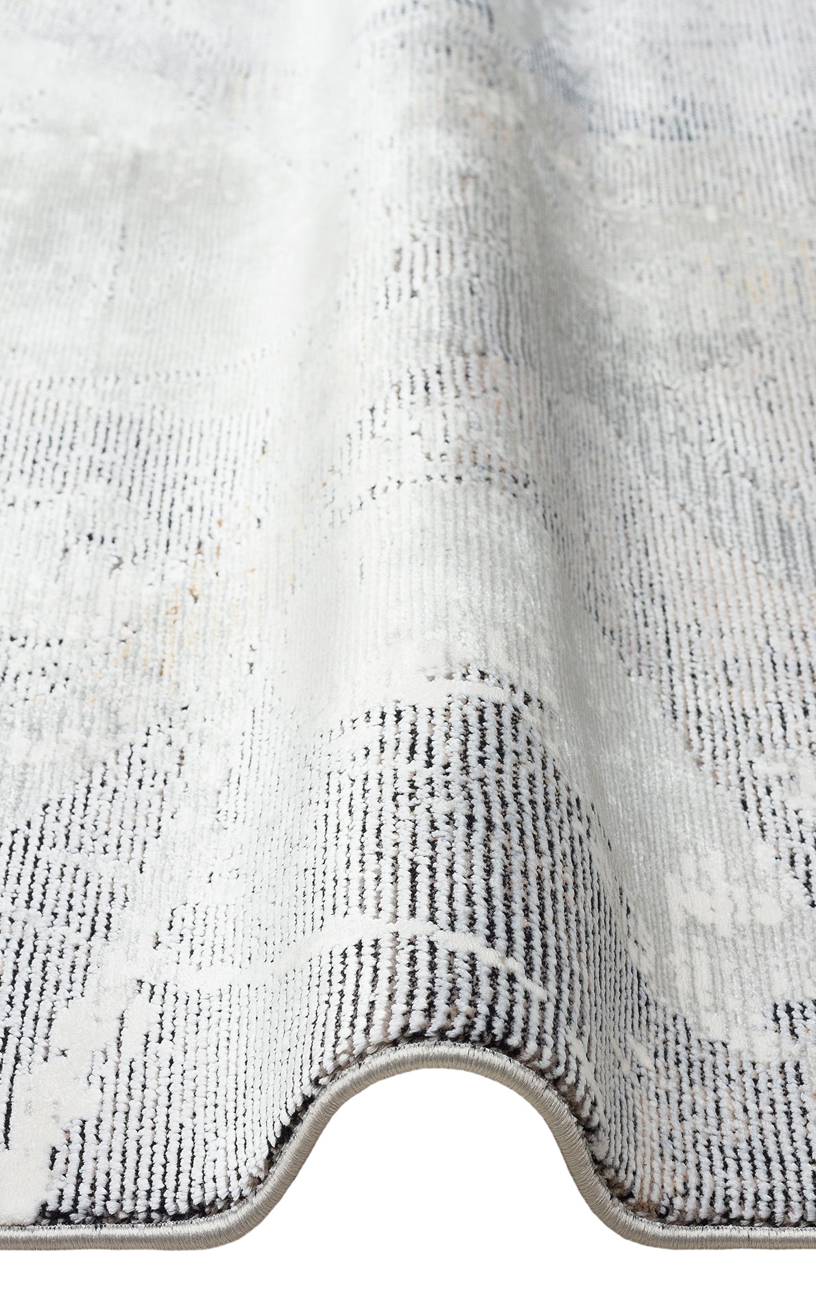 Grey and white area rug with a distressed, faded traditional pattern and a serged edge.