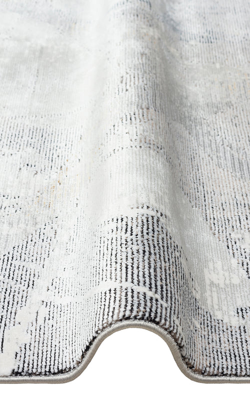 Load image 1 in gallery view. Grey and white area rug with a distressed, faded traditional pattern and a serged edge.