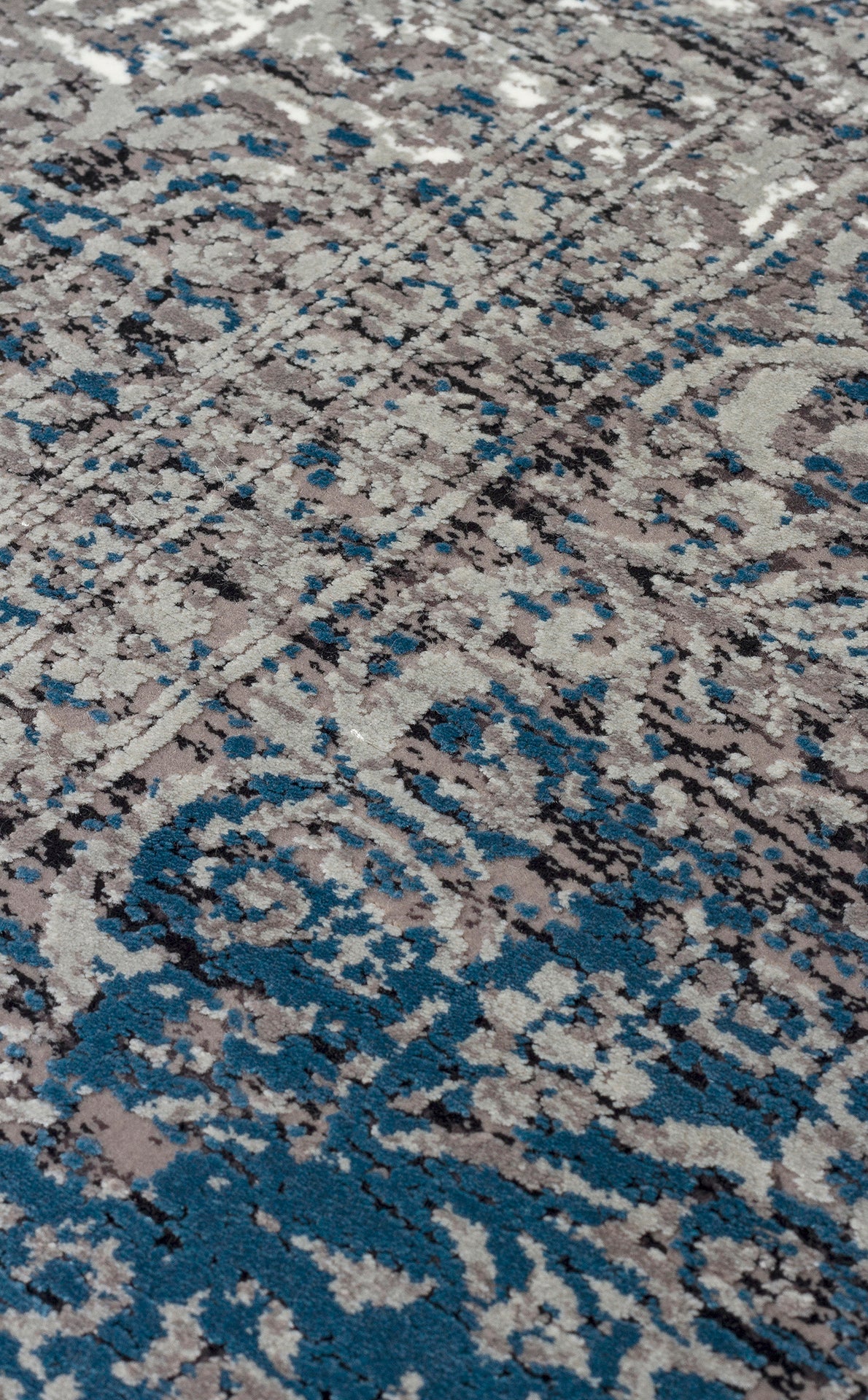 Grey, blue, and black distressed rug with a faded traditional medallion pattern.