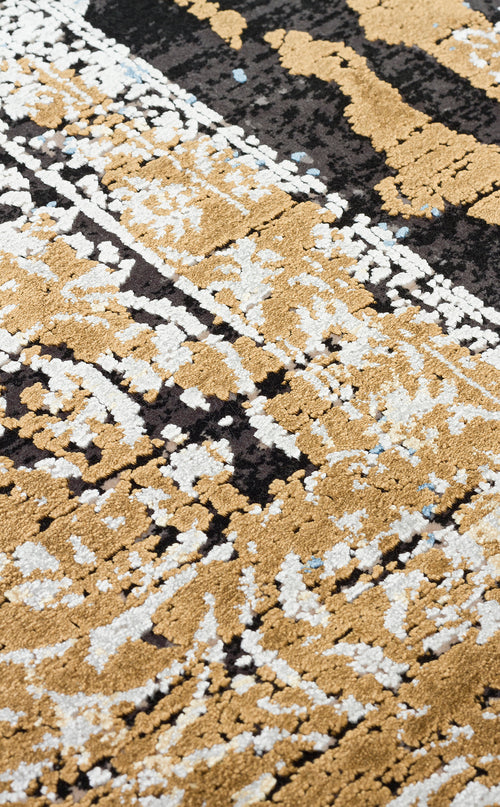 Bild 1 in Galerieansicht laden. Close-up of a rug with a distressed, textured pattern in gold, white, and black with small blue accents.