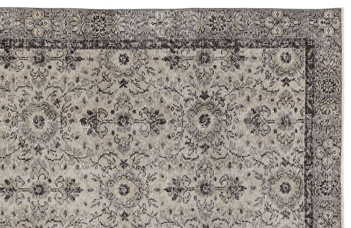 Charcoal and beige traditional rug with a distressed floral medallion pattern and a detailed border.