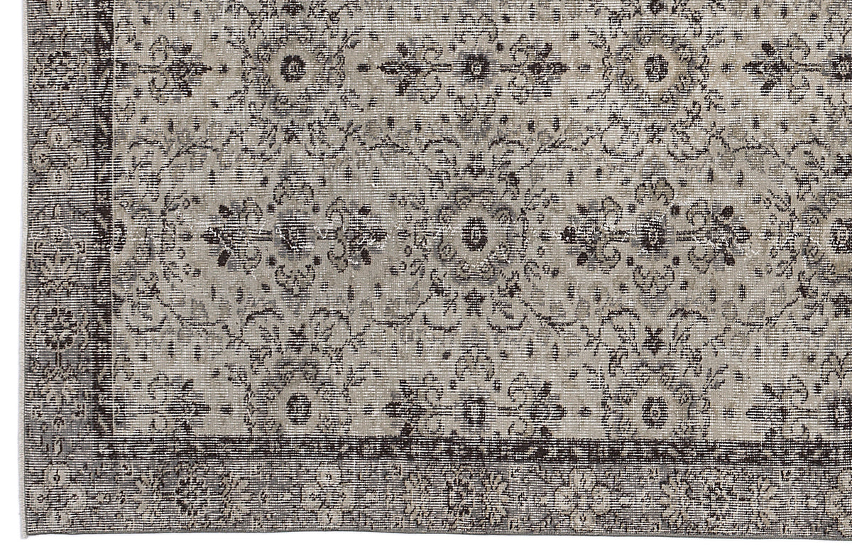 Grey and charcoal distressed rug with a traditional floral medallion pattern and a wide decorative border.