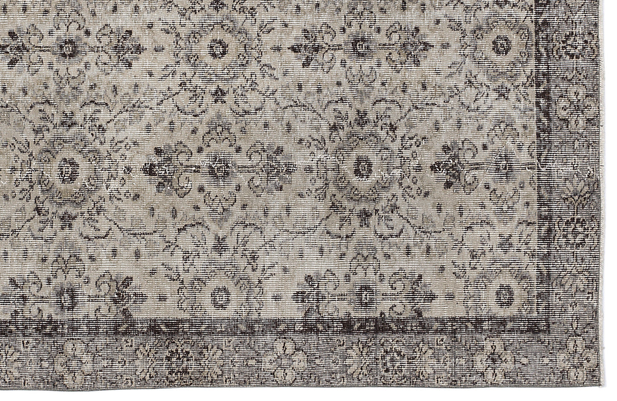 Grey and charcoal distressed rug with a traditional floral medallion pattern and a wide decorative border.