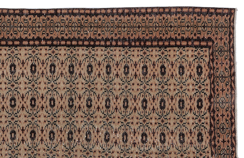 Load image 1 in gallery view. Tan and dark brown rug with a repeating geometric medallion pattern and a decorative border.