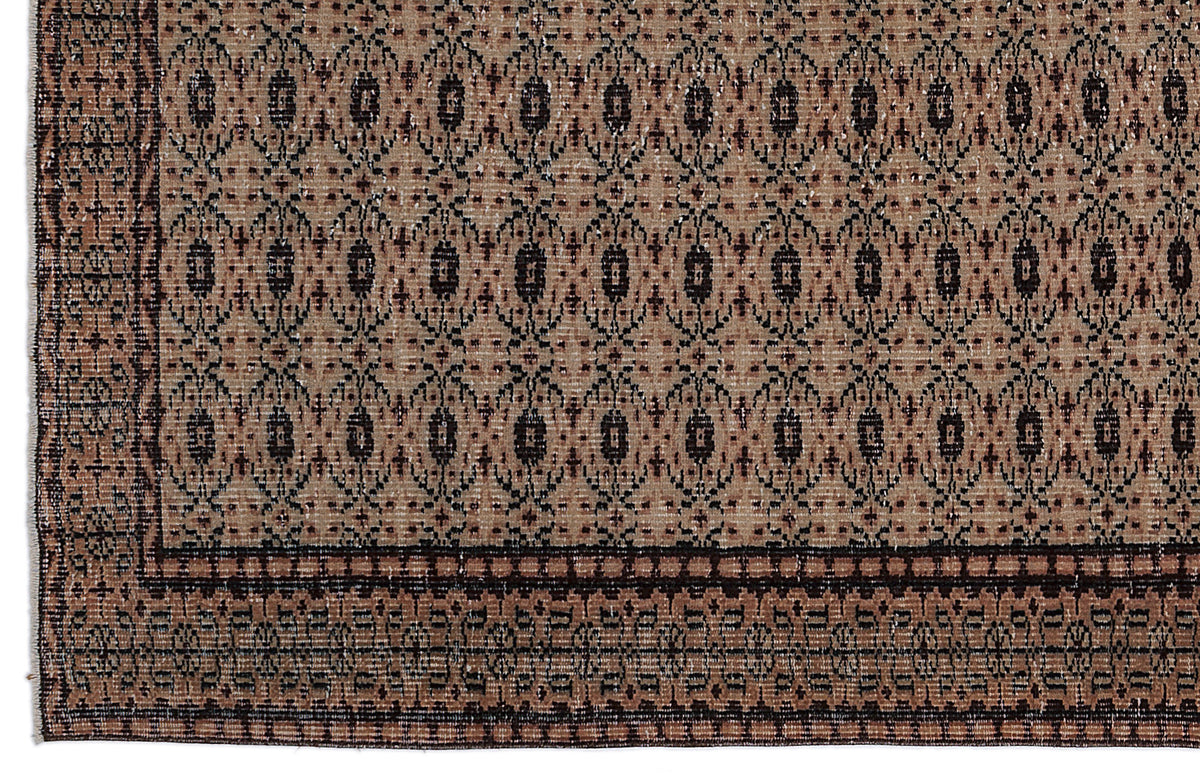 Tan and dark brown rug with a repeating geometric diamond pattern and a wide, detailed border.