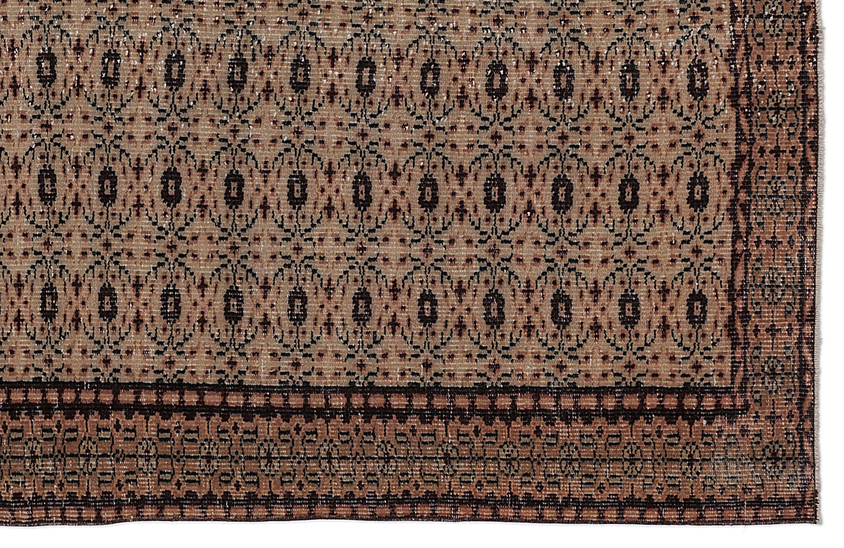 Tan and black traditional rug with a repeating geometric medallion pattern and a wide, detailed border.