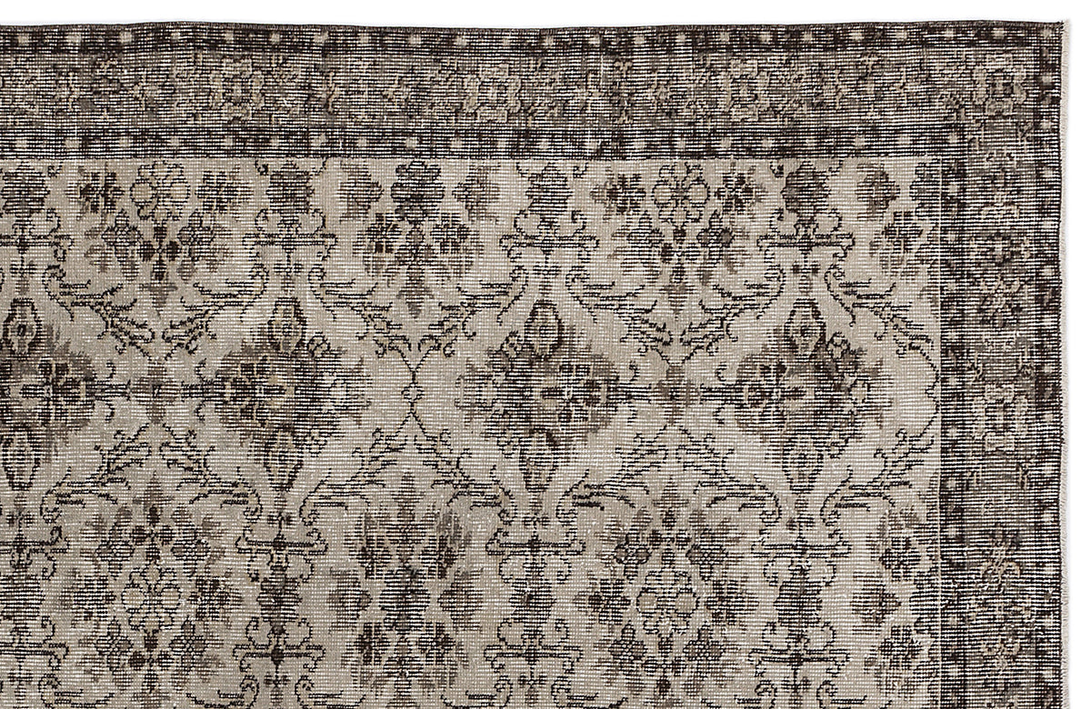 Charcoal and beige rug with a distressed traditional floral medallion pattern and a dark geometric border.
