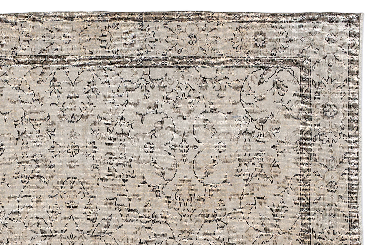 Beige and charcoal grey rug with a distressed floral medallion pattern and a detailed geometric border.