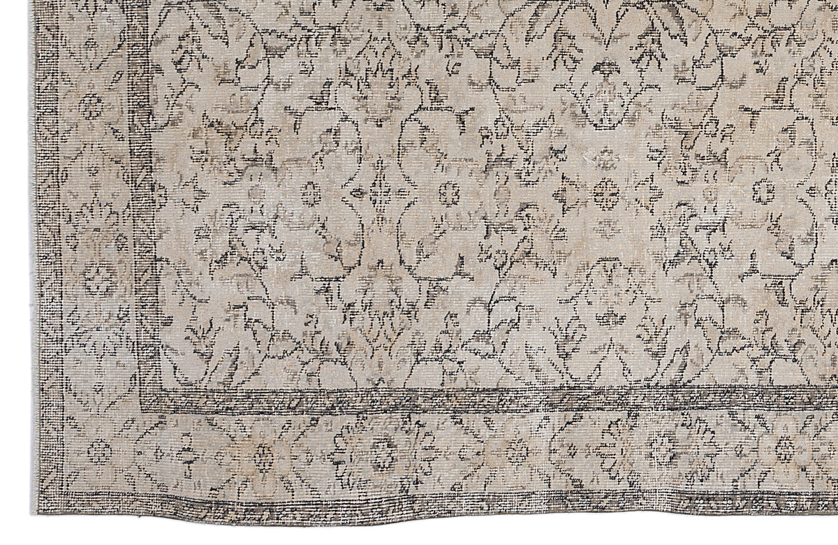 Beige and charcoal grey rug with a distressed traditional floral medallion pattern and a detailed border.