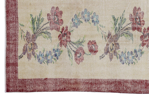 Load image 1 in gallery view. Beige rug with a red border and a central floral pattern in red, blue, and green.