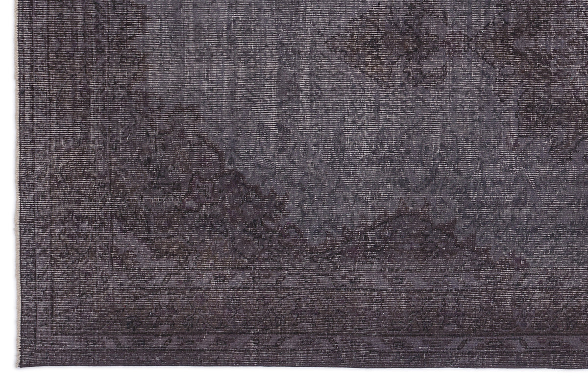 Charcoal grey rug with a distressed, faded traditional medallion pattern and a linear border.