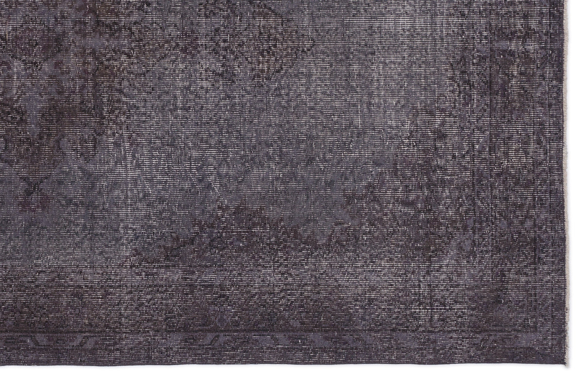 Charcoal grey rug with a distressed, faded traditional medallion pattern and a linear border.