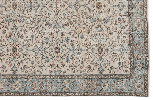 Load image 1 in gallery view. Cream rug with a distressed floral trellis pattern in muted blue, brown, and pink, featuring a wide decorative border.