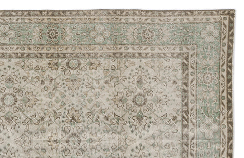 Load image 1 in gallery view. Distressed beige and sage green rug with a traditional floral medallion pattern and a geometric border.