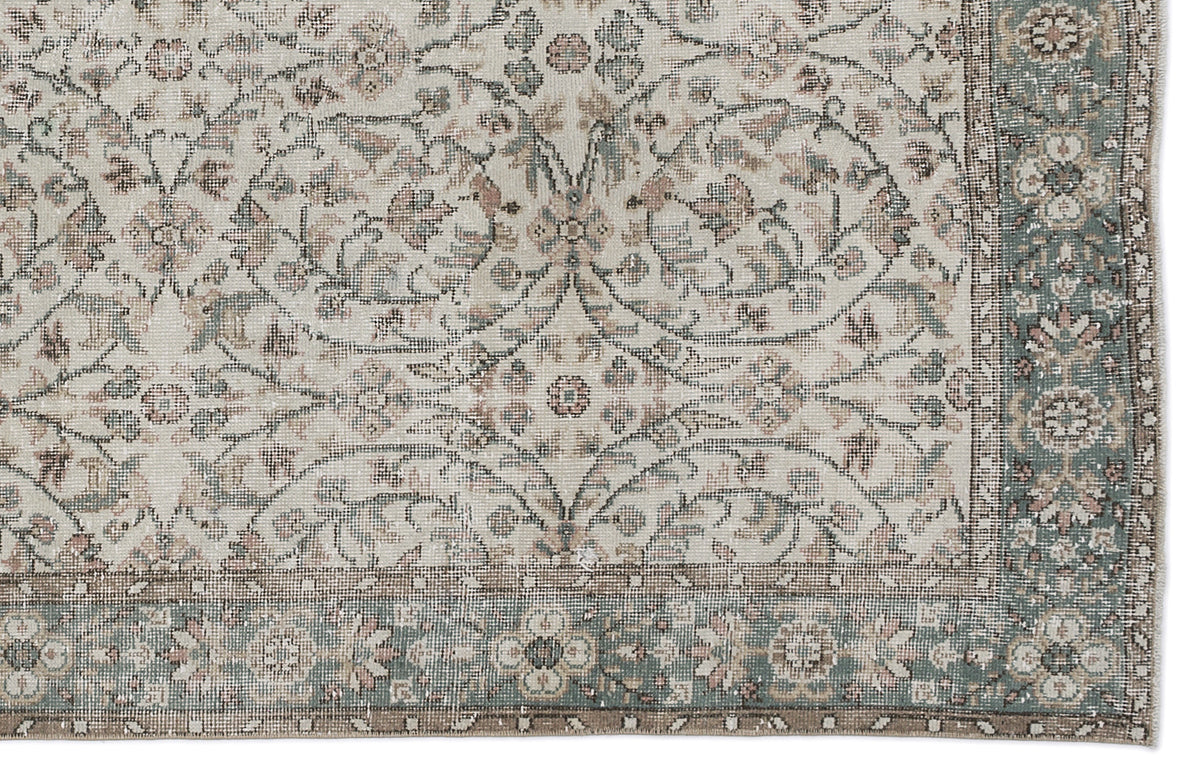 Beige, sage green, and muted pink traditional rug with a distressed floral medallion pattern and a decorative border.