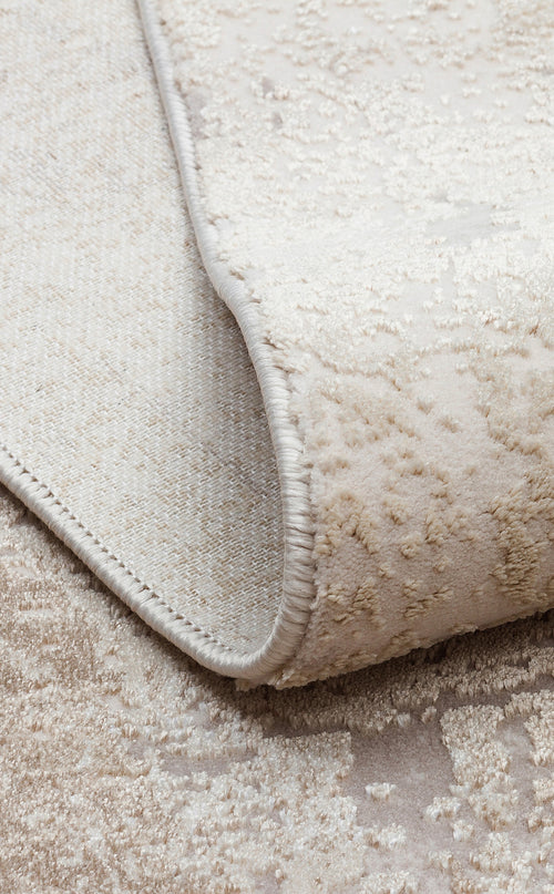 Bild 1 in Galerieansicht laden. Beige and cream textured rug with a subtle distressed pattern, showing the woven backing and serged edge.
