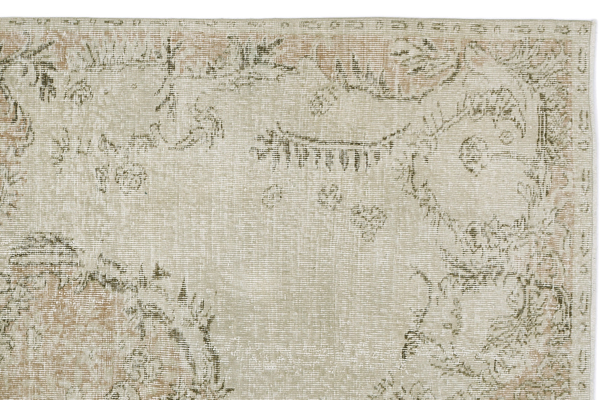 Beige and sage green distressed rug with a faded traditional floral medallion pattern on a white background.