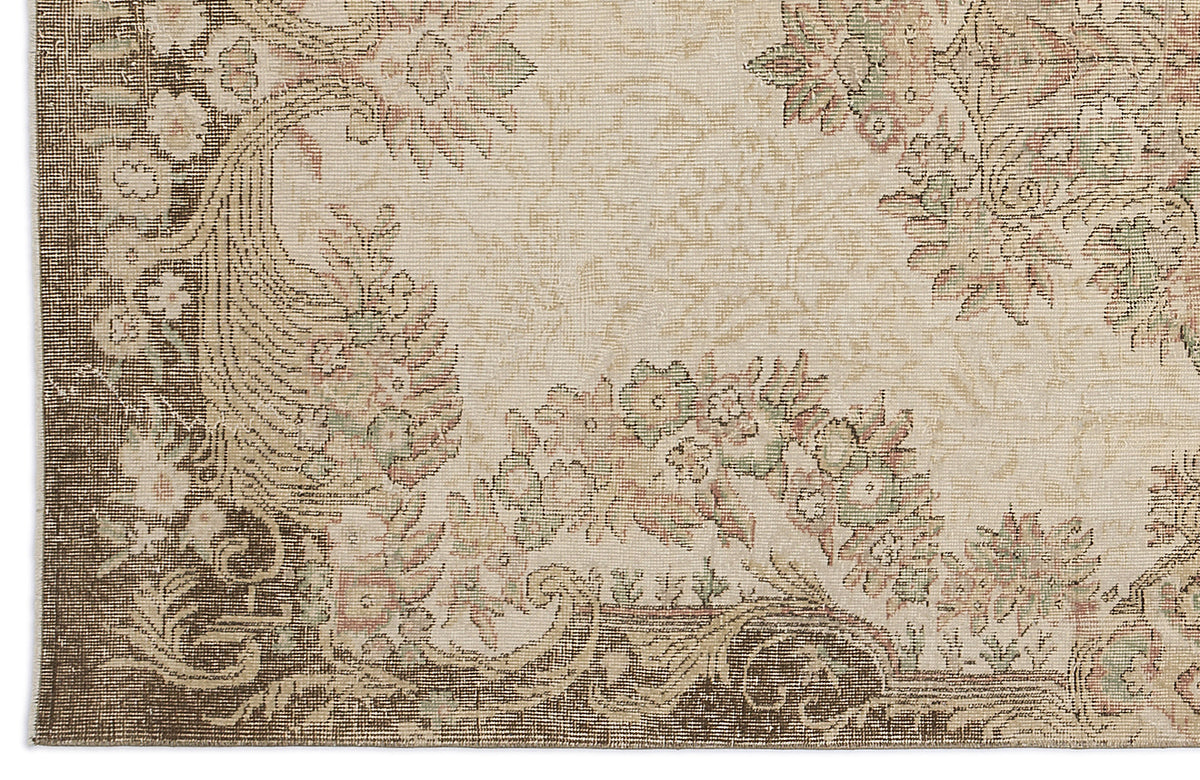 Beige and brown rug with a traditional floral medallion pattern and distressed texture.