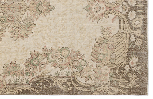 Load image 1 in gallery view. Beige rug with a dark brown border and muted floral motifs in sage green and dusty pink.