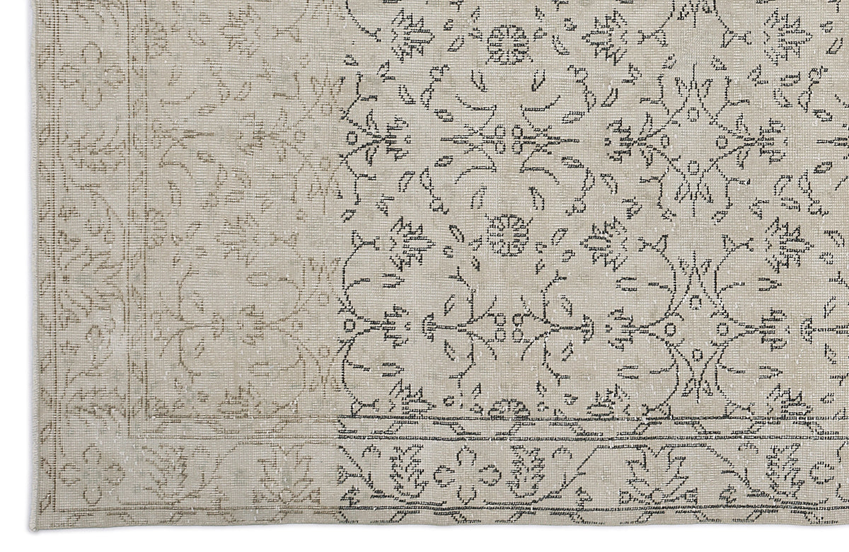 Beige and grey rug with a faded traditional floral medallion pattern and a decorative border.